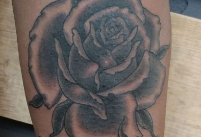 black and grey traditional style rose stem tattoo featured