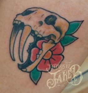Traditional saber tooth skull tattoo by Jake B